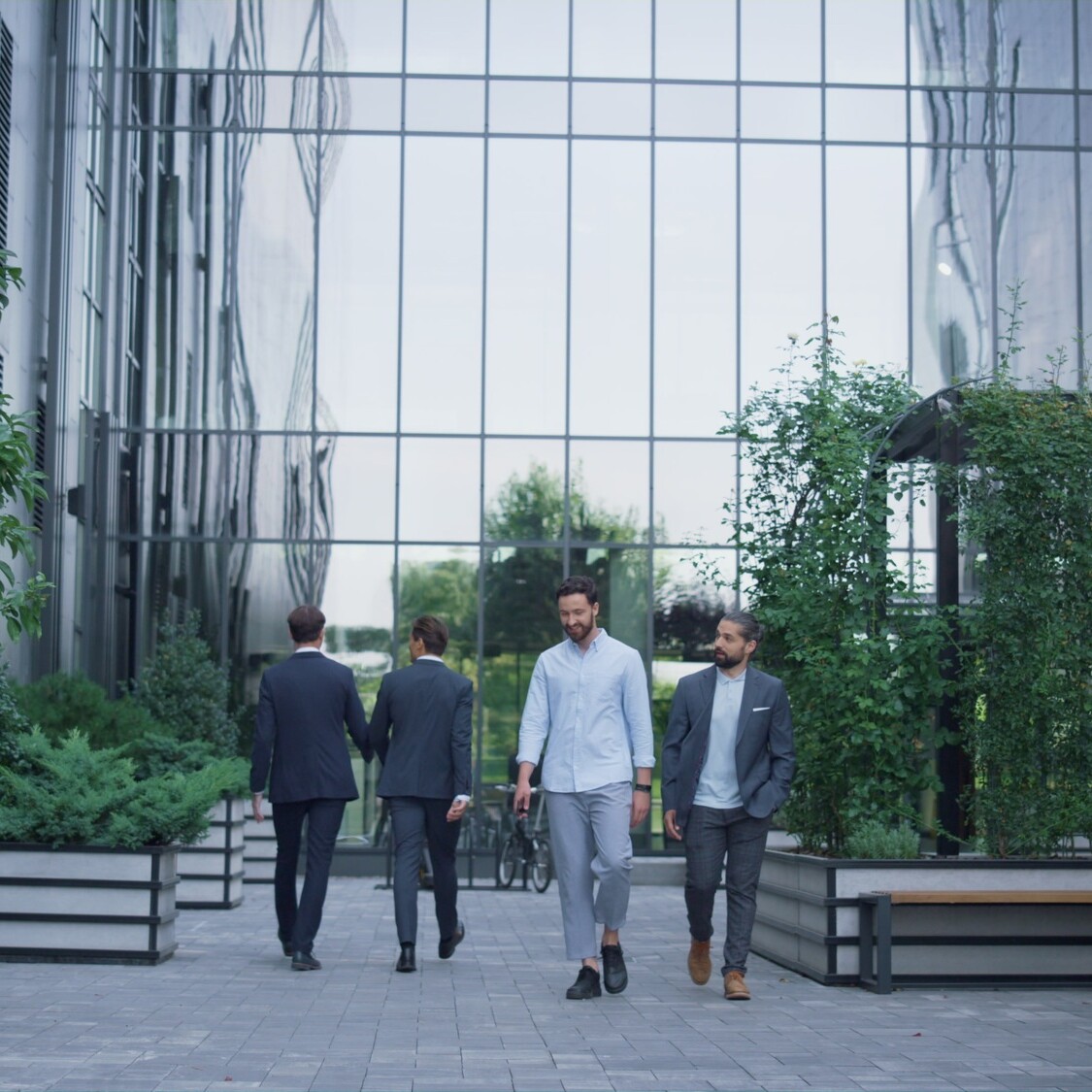 Business people walking office building garden. Daily routine at downtown area.