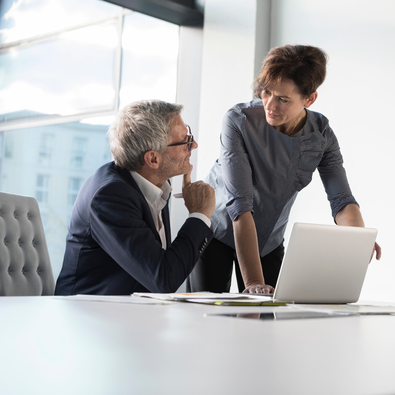 Businessman and businesswoman with laptop in office