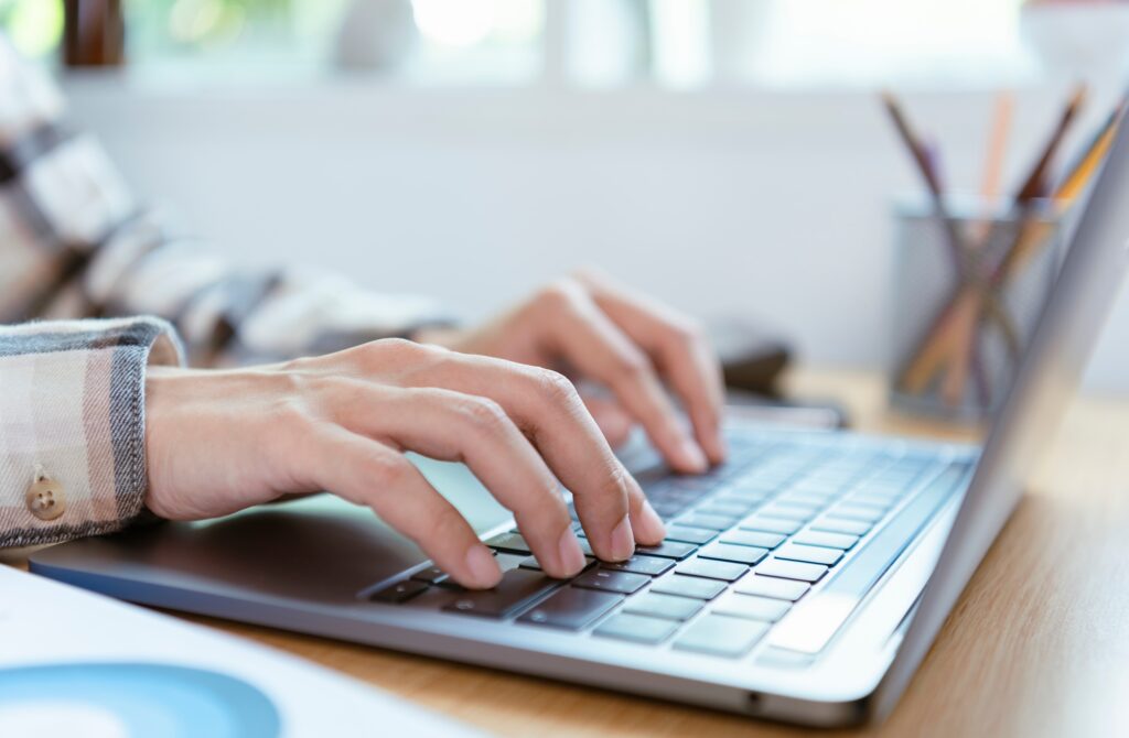 Businesspeople hands typing laptop keyboard on desktop office.