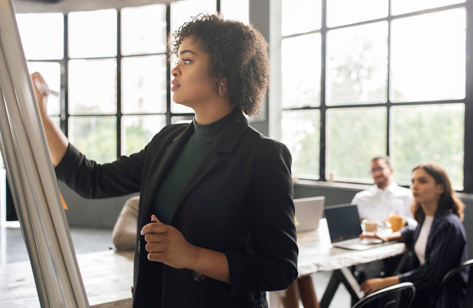 Lady Writing On Whiteboard Making Presentation For Team At Office