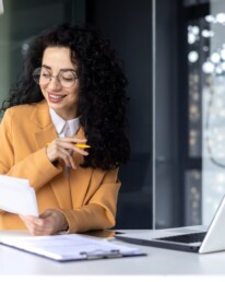 latin american businesswoman working inside office with documents and laptop, worker paperwork
